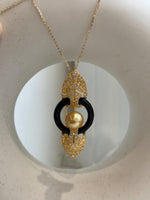 Convertible South Sea pearl brooch pendant with intricate openwork and clear stone accents.