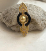 South Sea golden pearl brooch pendant with glossy black curved accents and ornate gold tone details.
