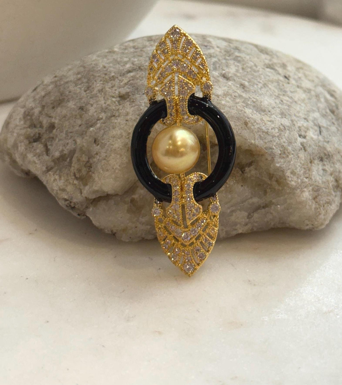 Art Deco inspired South Sea golden pearl brooch with symmetrical filigree and sparkling clear stones.