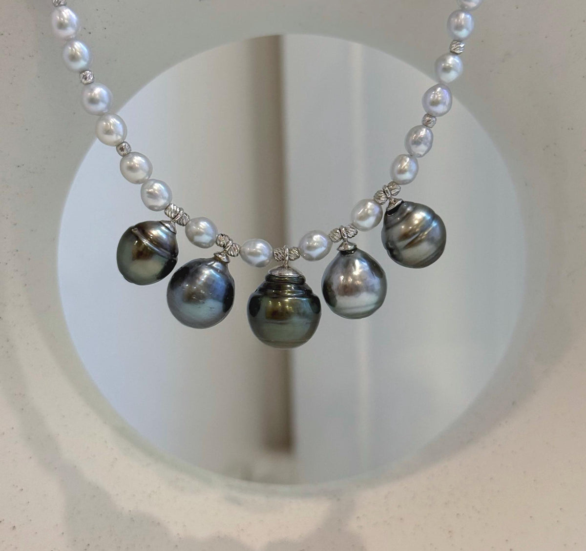 Close view of the central Tahitian pearl with dark metallic overtones.