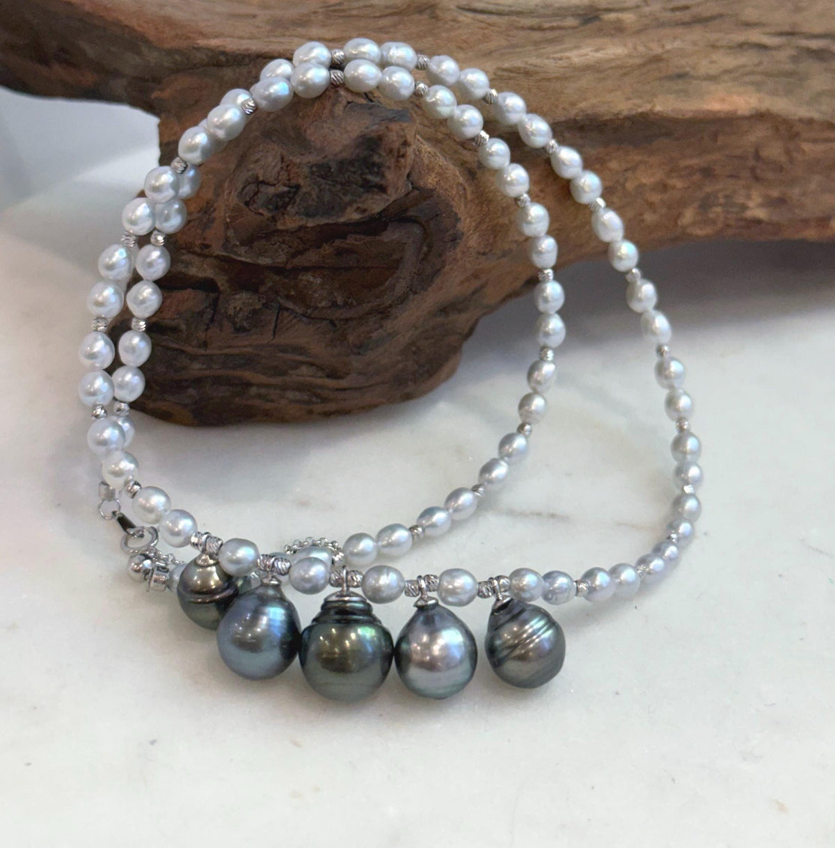 White pearls and sterling silver spacer beads along the necklace strand.