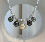 Detail of the platinum and golden pearl drops against the smaller white pearls.