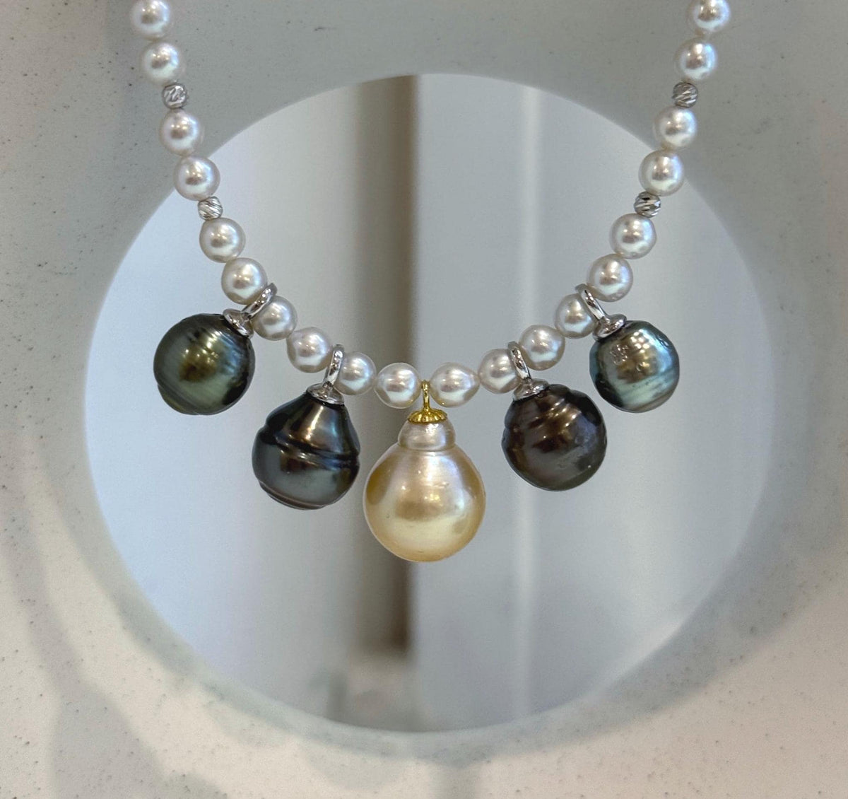 Detail of the platinum and golden pearl drops against the smaller white pearls.