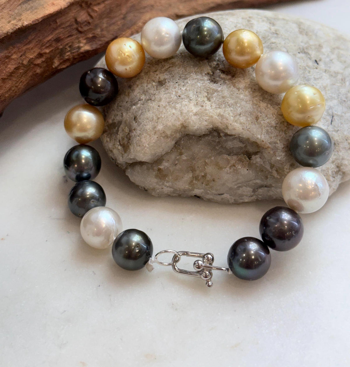 White and golden ocean pearls mixed with charcoal pearls.