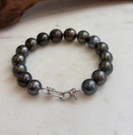 Hunter green Tahitian pearls with lustrous surfaces.