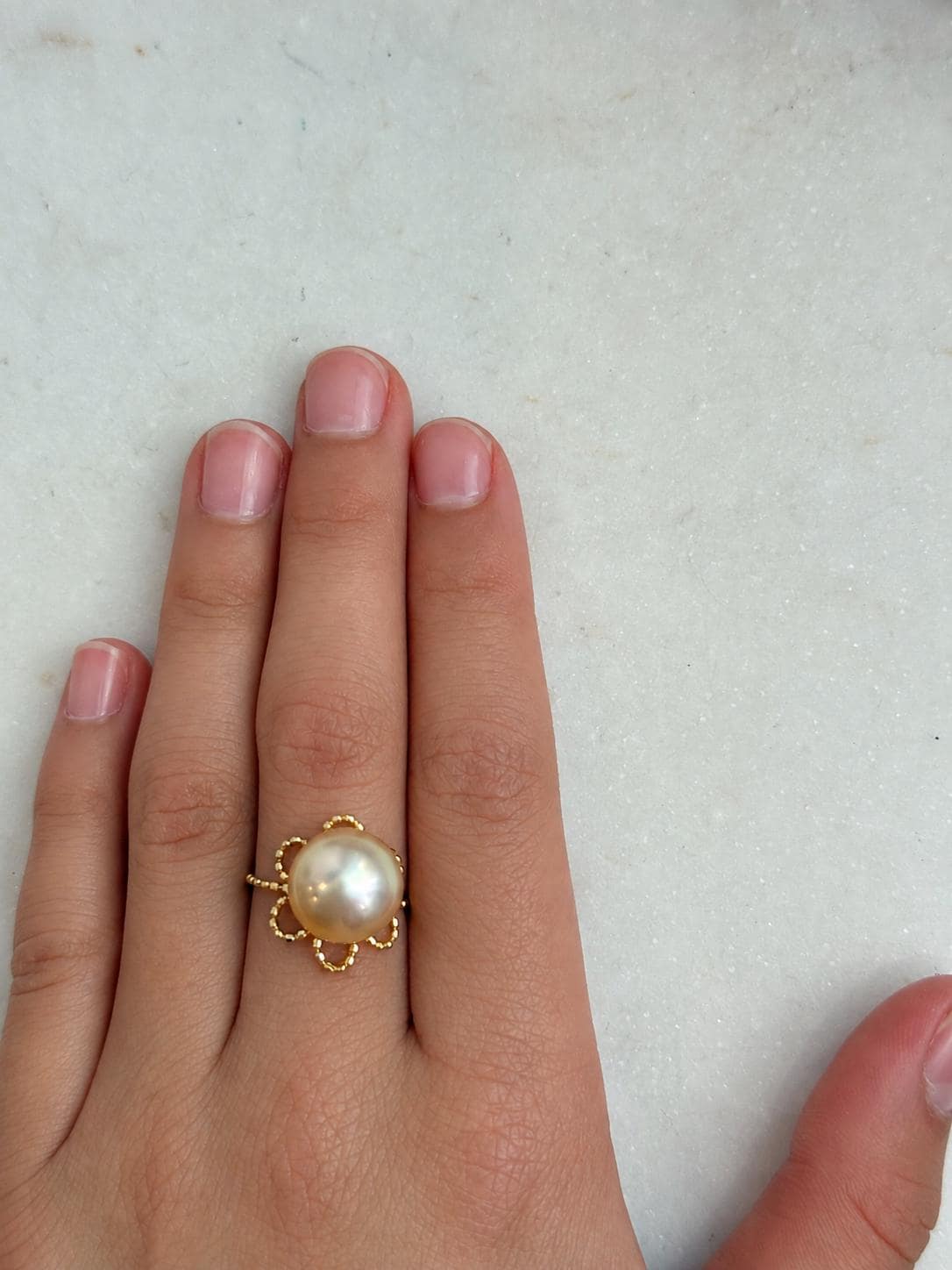 Vintage-style floral lace ring featuring a lustrous golden South Sea pearl and an adjustable band.