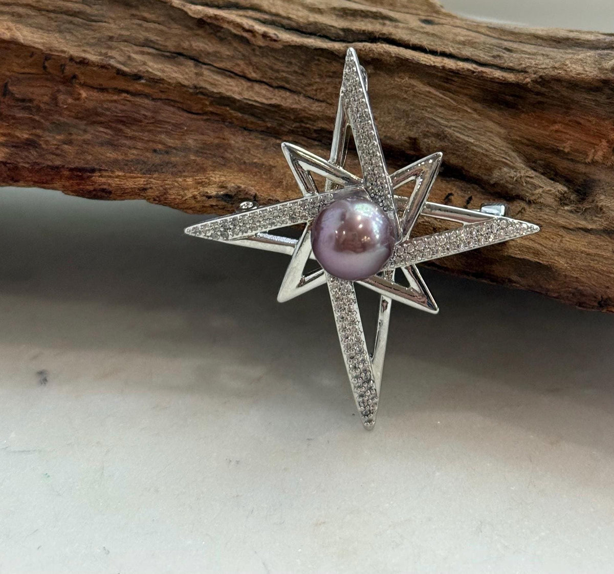 Purple Edison pearl set at the centre of a star brooch pendant.