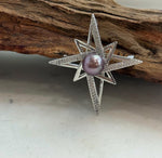 Star-shaped pearl brooch pendant shown from the front.