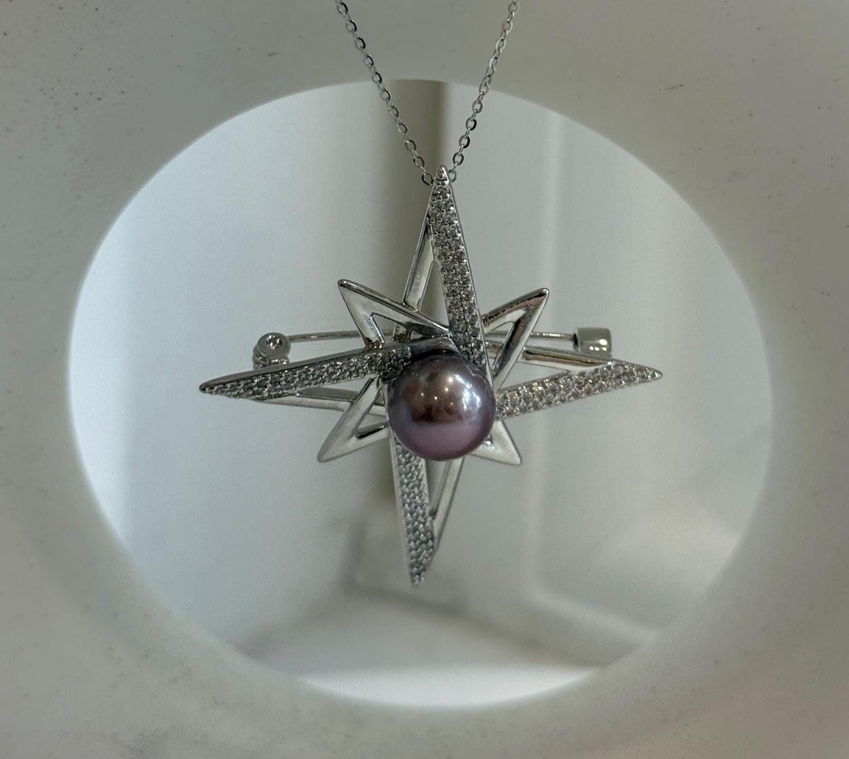 Two-in-one star jewelry piece worn as a brooch.