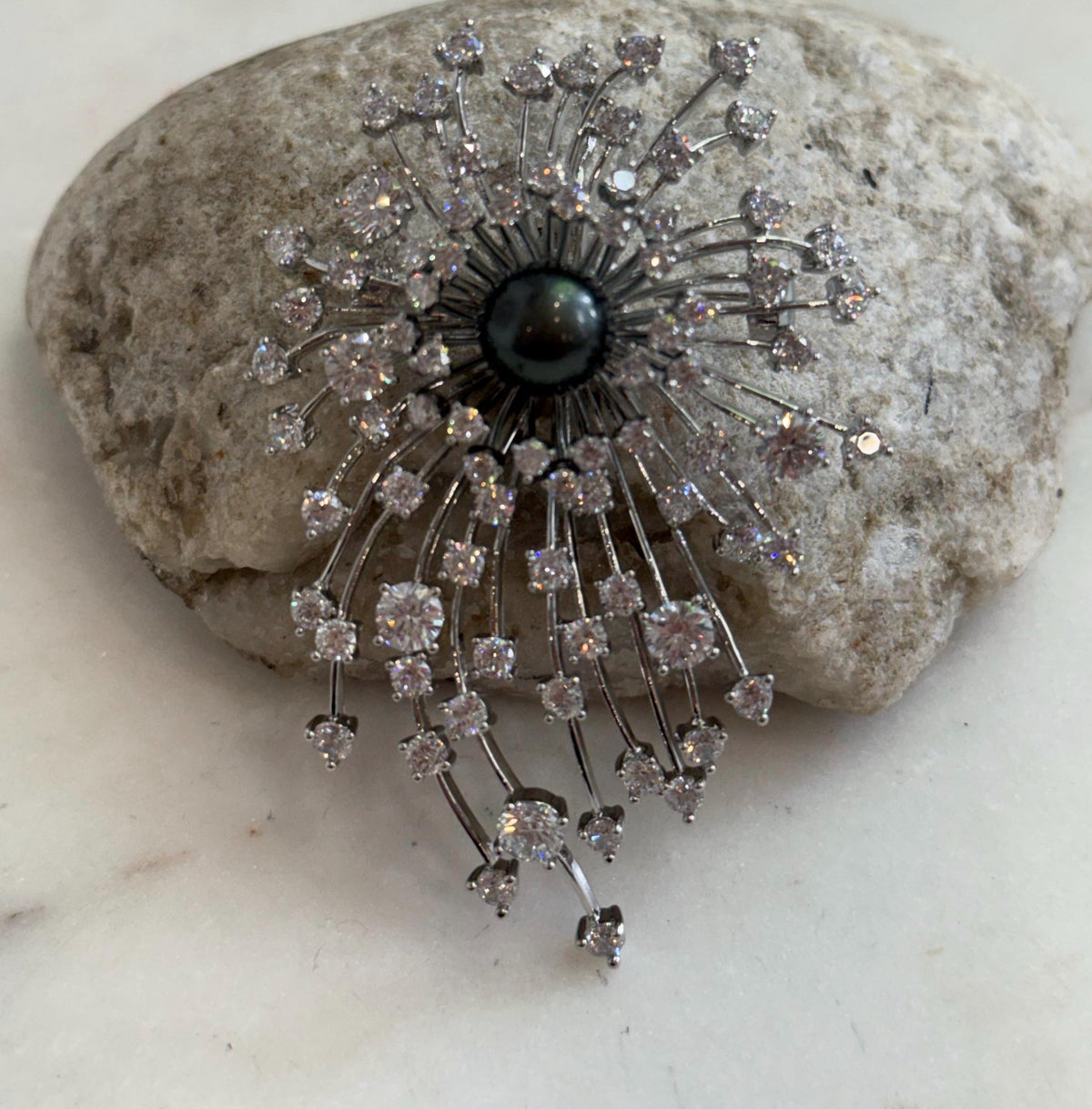 Piano black ocean pearl adding a dramatic focal point to the brooch pendant.