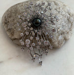 Piano black ocean pearl adding a dramatic focal point to the brooch pendant.