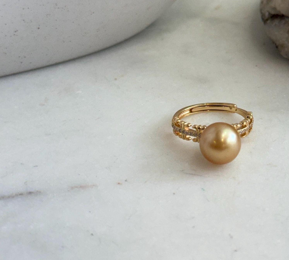 South Sea golden pearl ring displayed on a white ceramic vase.