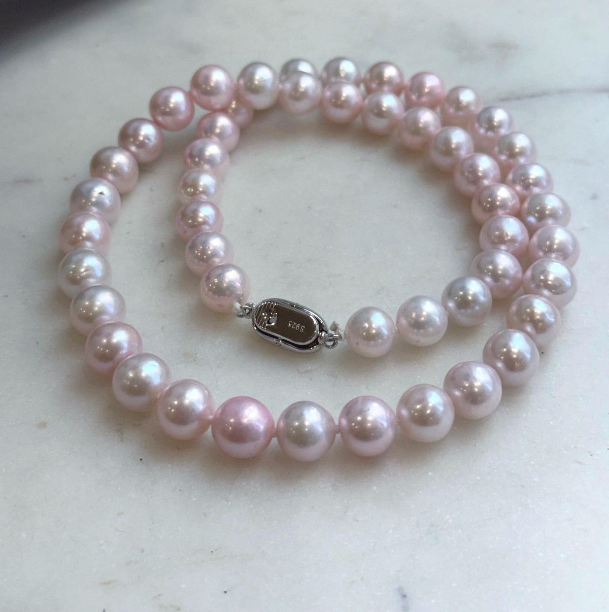Fifty pale pink freshwater pearls with brilliant luster.
