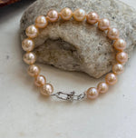 Lustrous peach freshwater pearls with a silver clasp