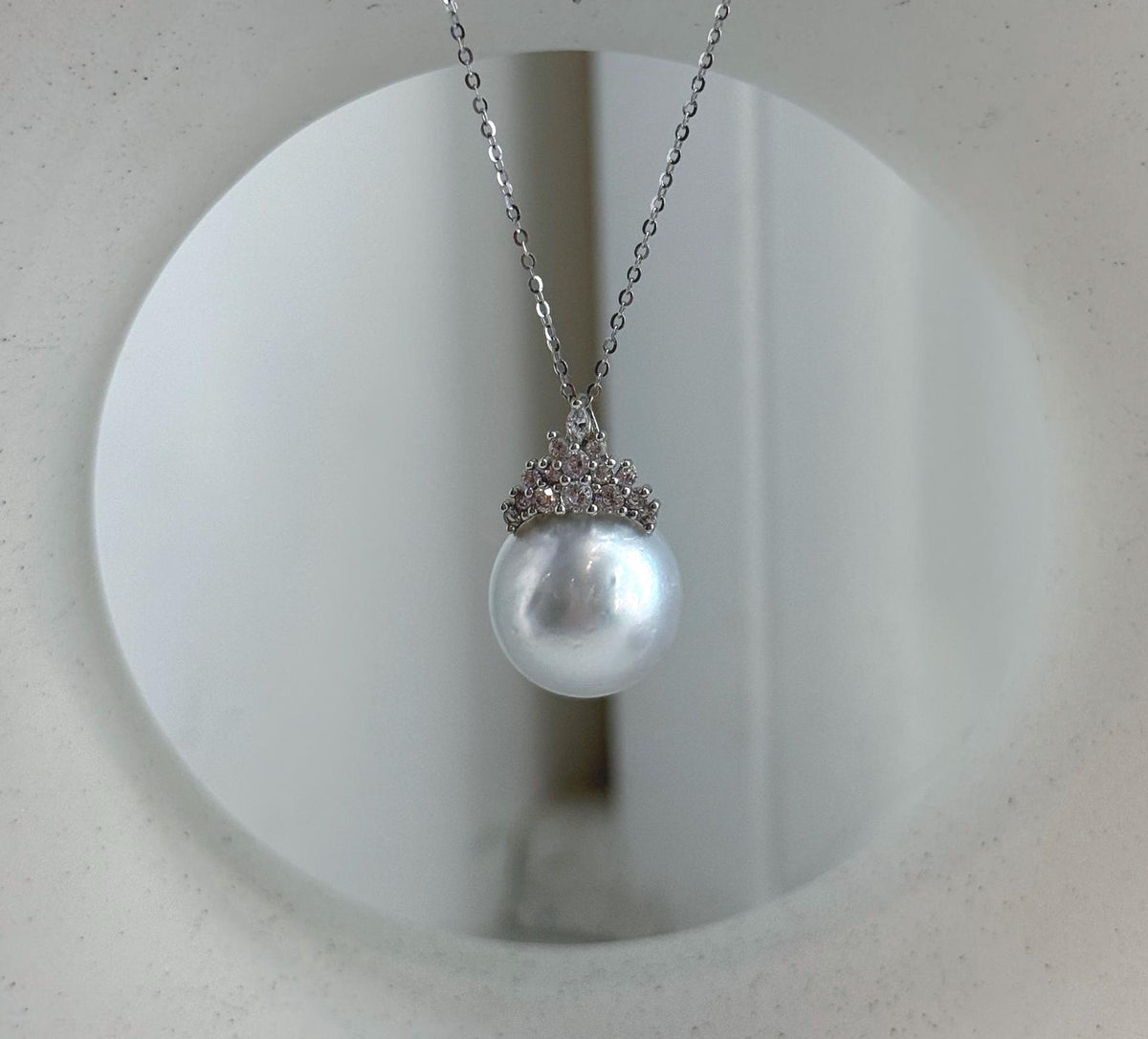 Close-up of the pearl pendant’s sparkling crown setting