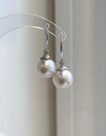Close-up of white Edison pearls with soft rosy overtones and reflective luster.