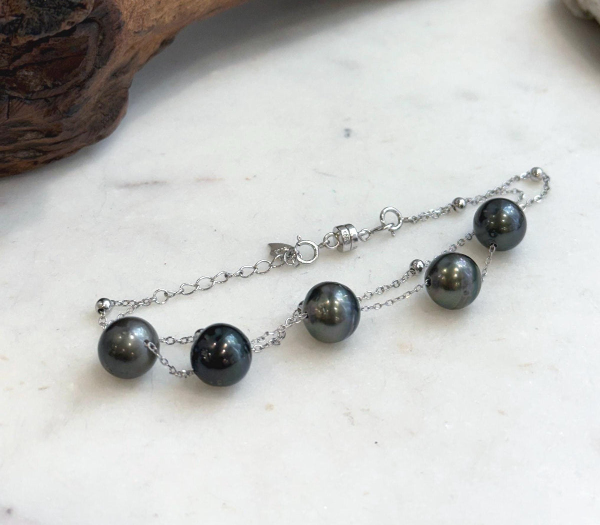 Adjustable Tahitian pearl bracelet with a silver extender chain and small heart charm.