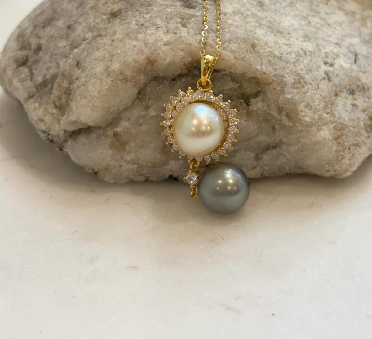 South Sea golden and Tahitian pearl necklace displayed against a pale stand with a circular opening.