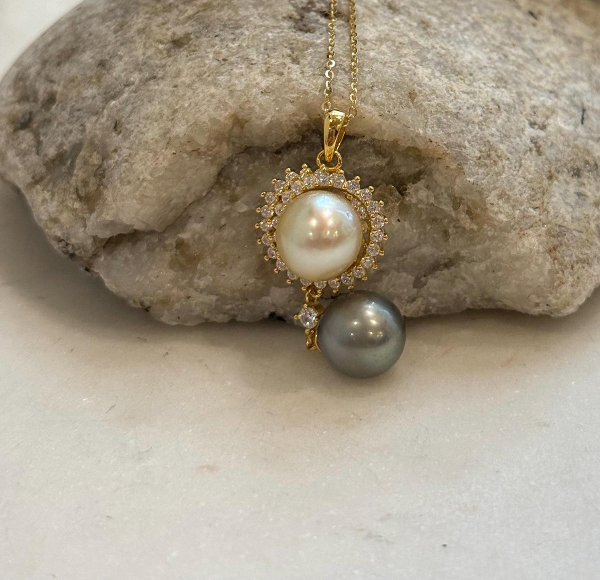 Close view of a golden South Sea pearl surrounded by a decorative halo of sparkling clear stones.