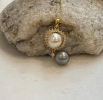 Close view of a golden South Sea pearl surrounded by a decorative halo of sparkling clear stones.