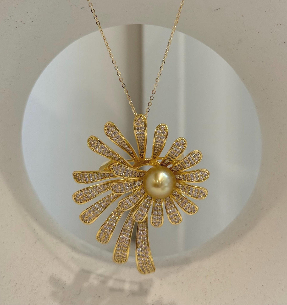 Two-in-one floral brooch and pendant featuring a golden pearl