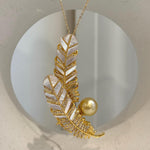 Feather pendant with a golden pearl and sparkling clear accents