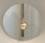 Lustrous golden ocean pearl pendant with crown-inspired detailing.