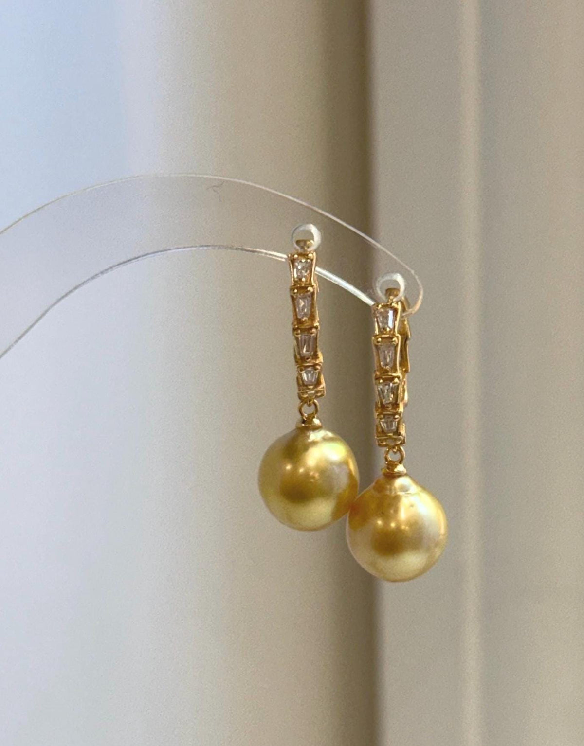 Pair of golden South Sea pearl earrings suspended from sparkling crystal-accented hoops.