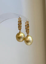 Front view of 11.1mm golden South Sea pearl hoop earrings.