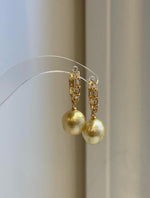Golden South Sea pearl hoop earrings with crystal-accented gold-tone hoops.