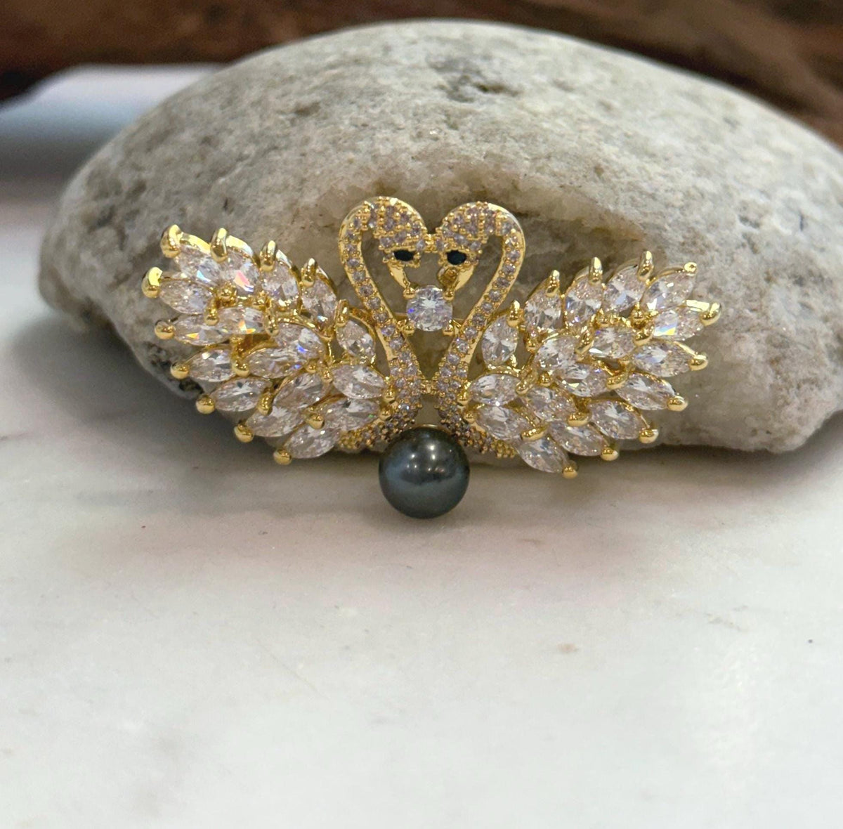 An elegant swan brooch pendant featuring a genuine Tahitian saltwater pearl. The pearl’s strong, mirror-like luster stands out within the graceful swan design.