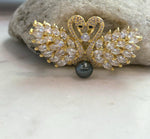 Front view of a two-in-one swan jewelry piece that can be worn as a brooch or pendant, with a genuine Tahitian pearl as its focal point.