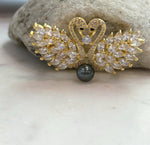 Elegant swan brooch with a genuine pearl as its focal point.