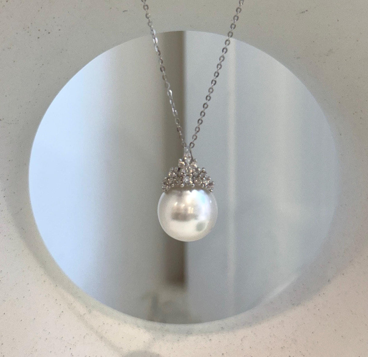 Rounded Australian South Sea pearl beneath an intricate sterling silver crown.