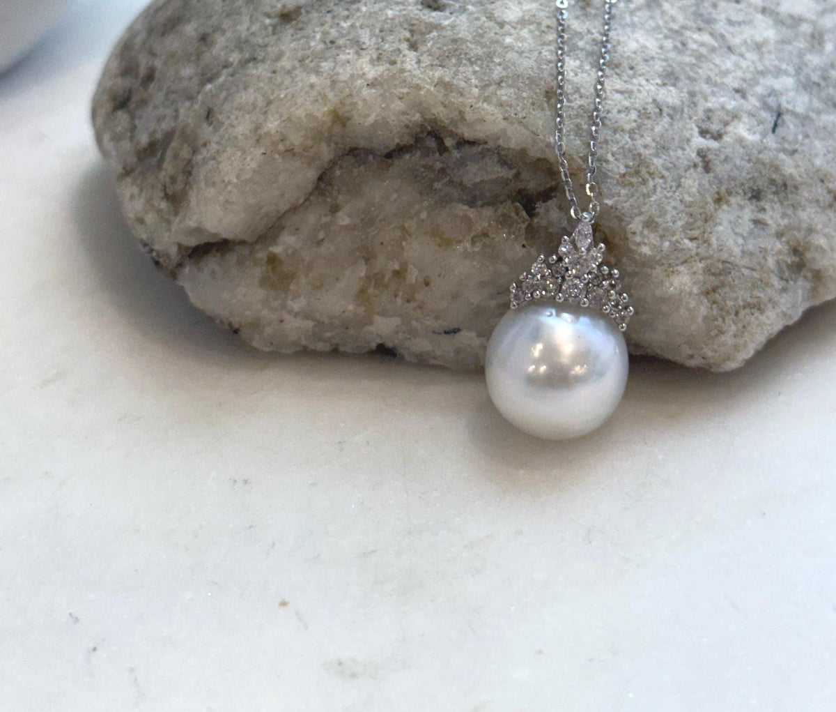 White ocean pearl pendant with subtle iridescent reflections and a sparkling crown cap.