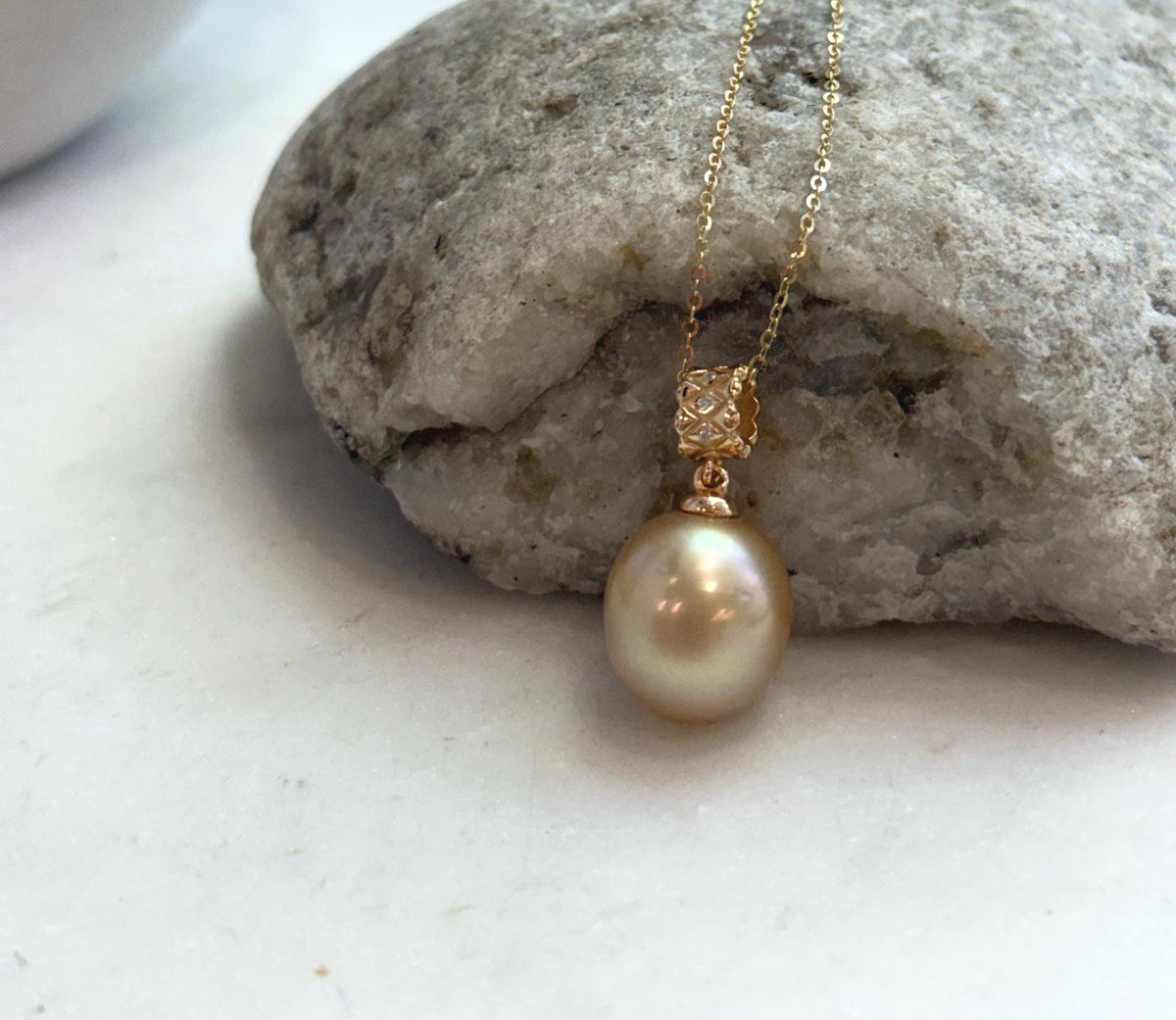 South Sea pearl pendant with a reflective surface and warm golden tones.