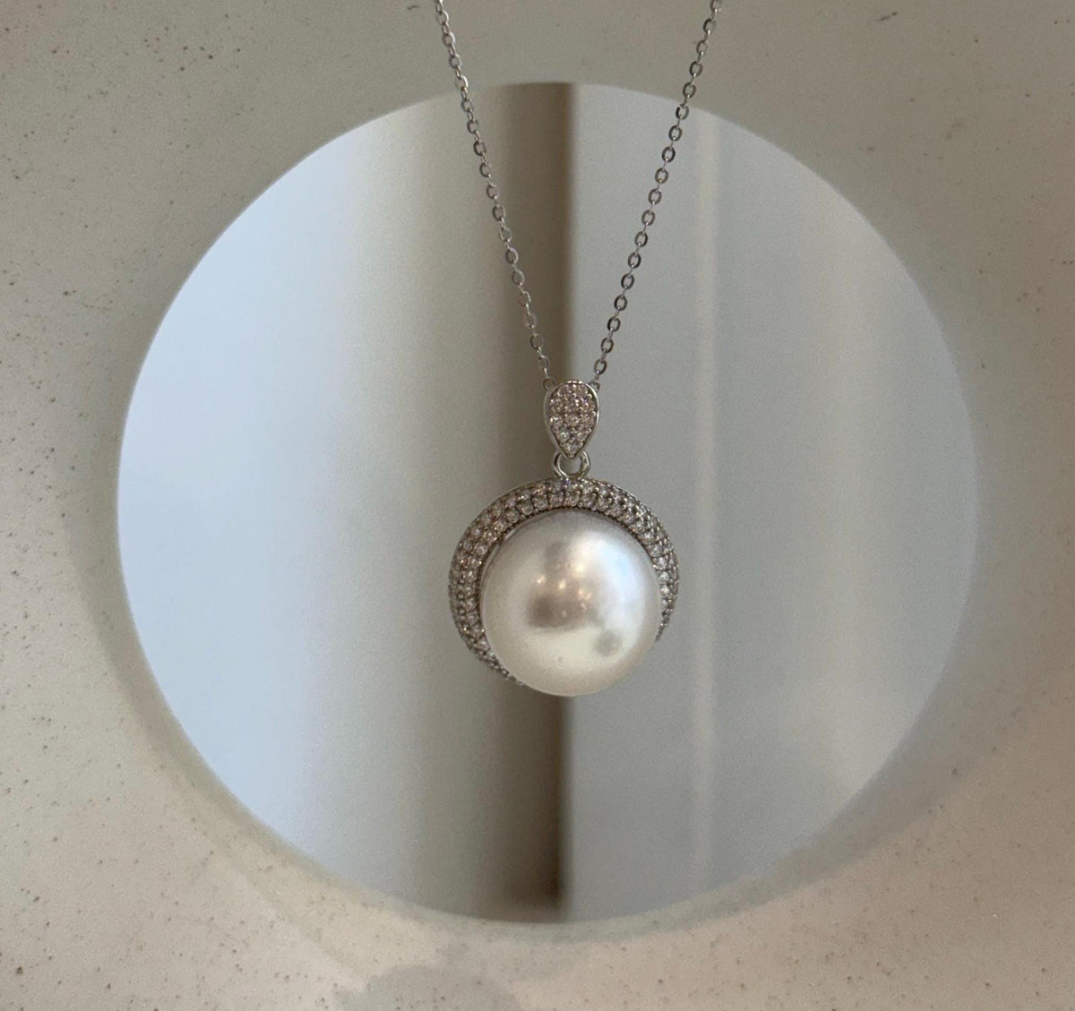 White Australian South Sea pearl with a highly reflective surface in a silver pendant.