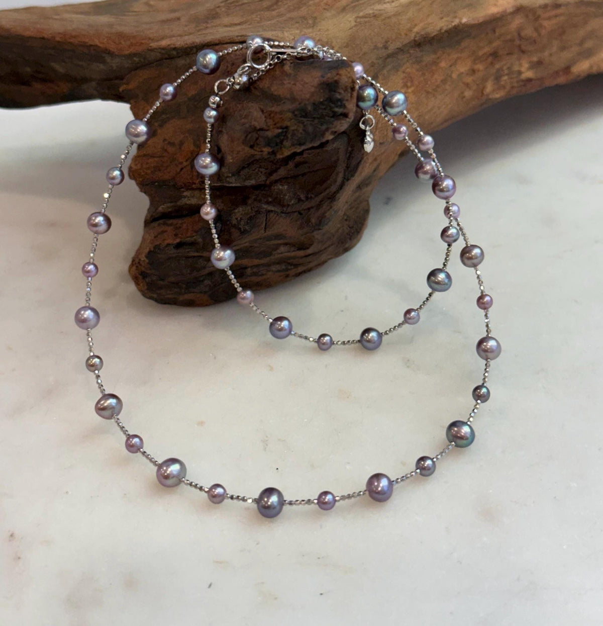 Freshwater pearl necklace featuring soft rose pink and rich purple colors