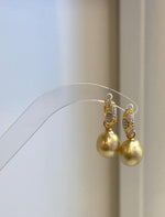 Detail of the crystal-accented gold-tone hoops above the golden pearls.