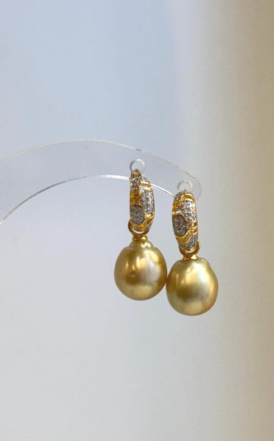 Side view showing the curved hoops and dangling golden pearl drops.