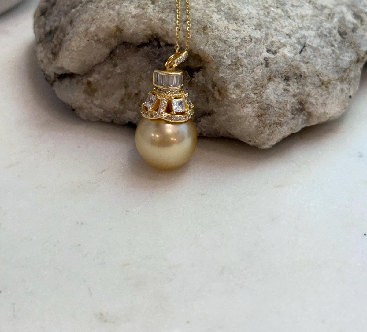 Front view of a golden South Sea pearl pendant on a delicate gold-tone chain.