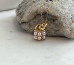Close-up of genuine ivory Akoya saltwater pearls on a handbag-shaped pendant