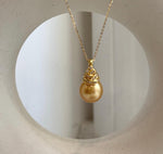South Sea pearl pendant with a reflective golden surface and sterling silver setting.