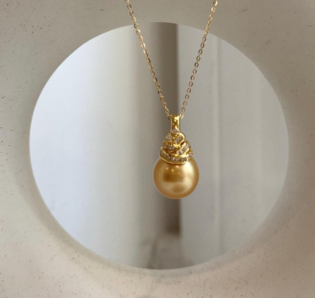South Sea pearl pendant with a reflective golden surface and sterling silver setting.