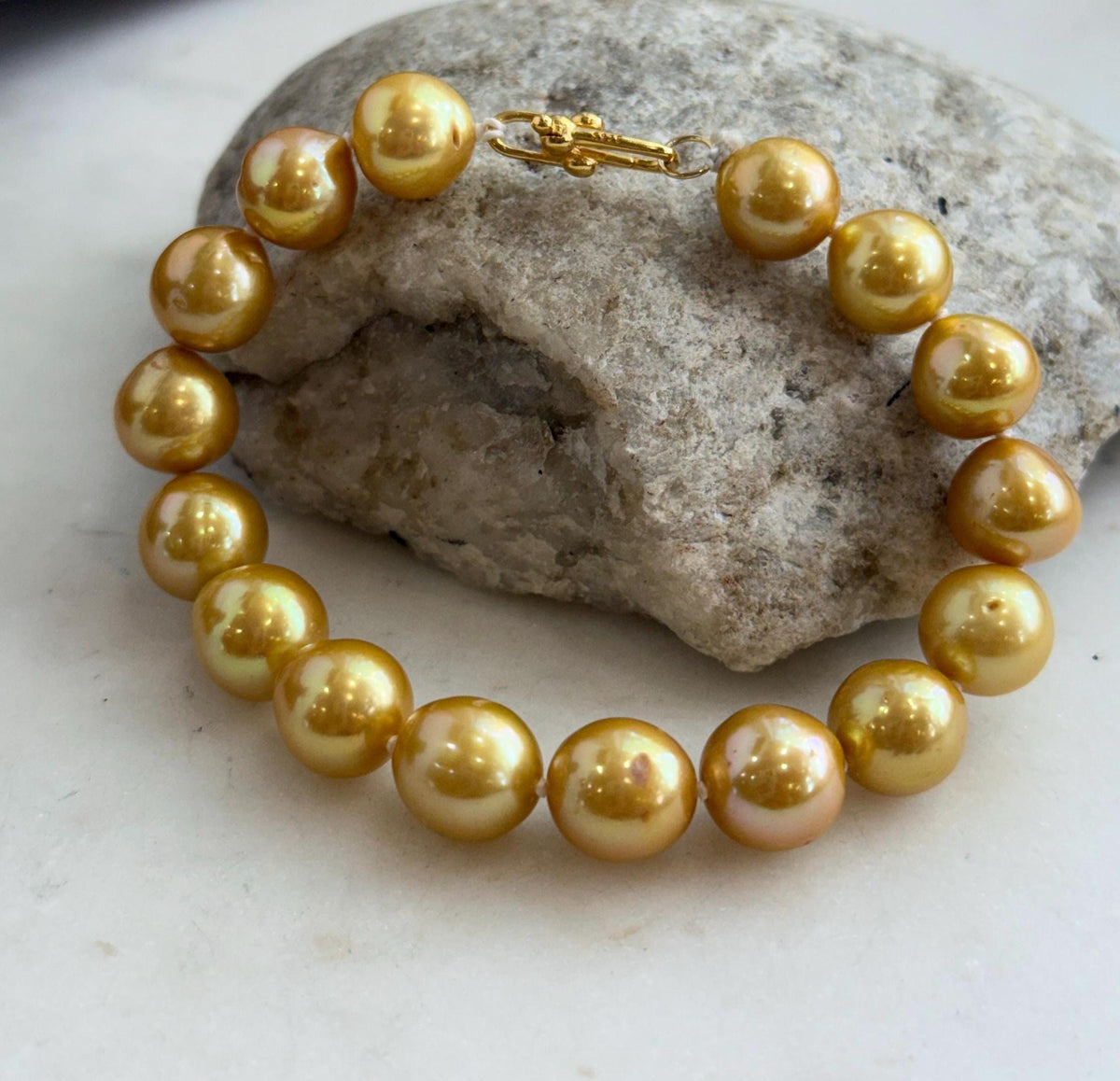 Close-up of golden Edison pearls showing their bright mirror-like luster.