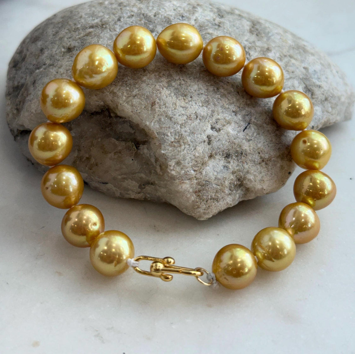 Sixteen golden freshwater pearls arranged in a classic strand bracelet.