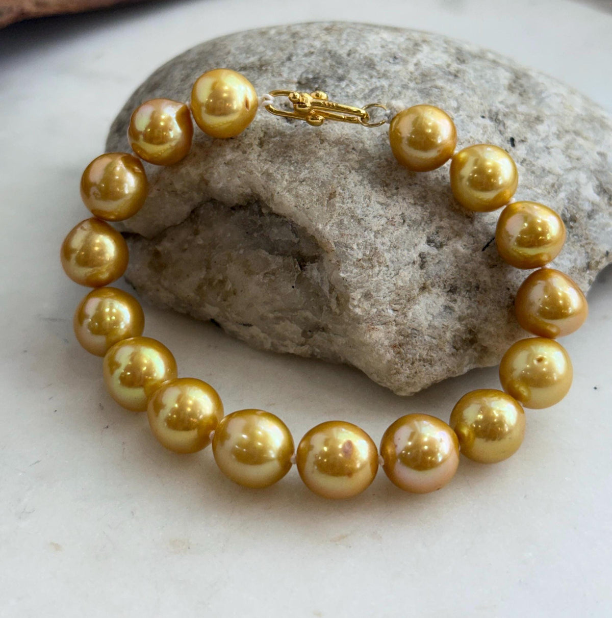 Close-up of genuine golden Edison pearls with glossy, mirror-like reflections.
