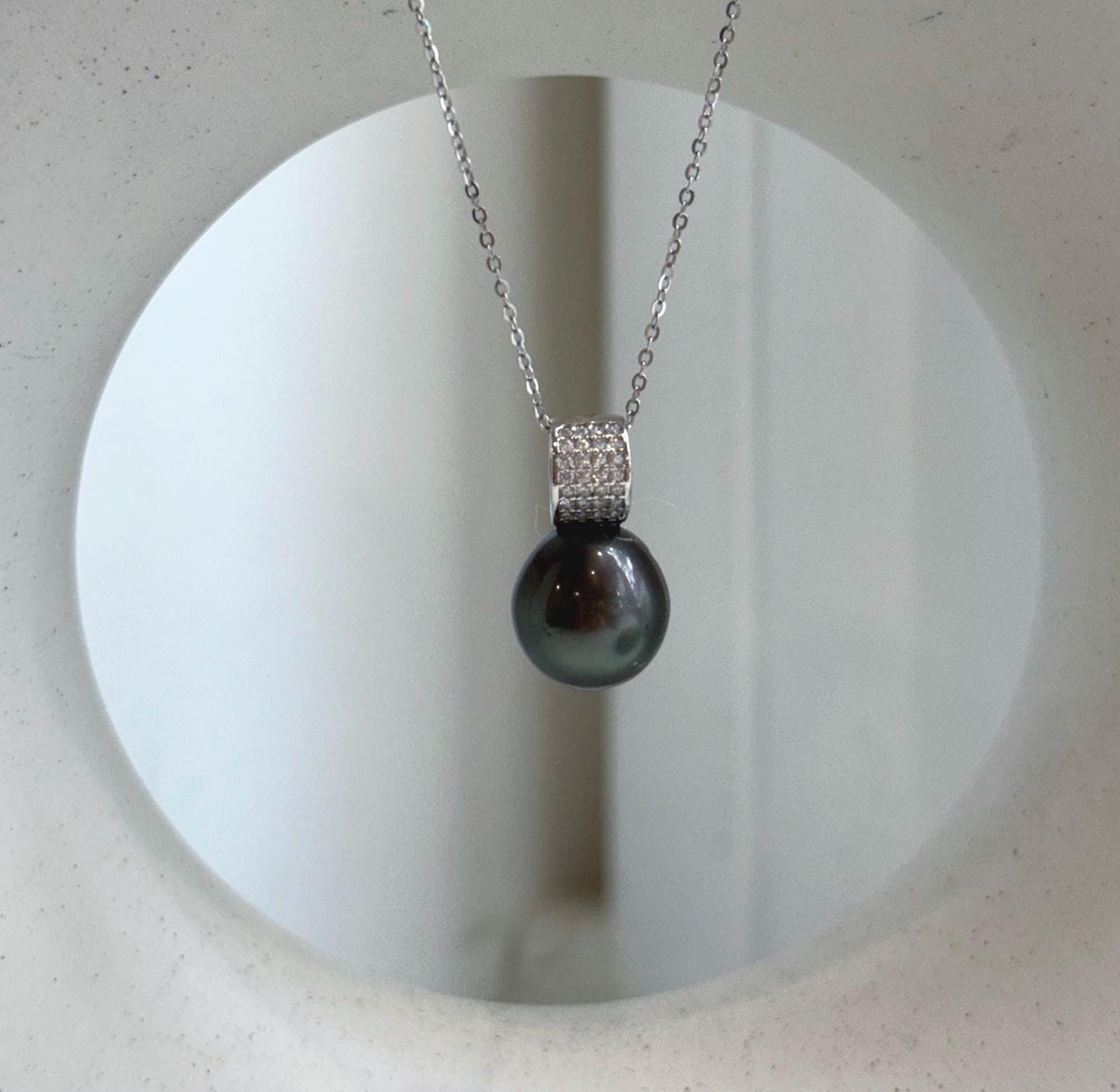 Elly’s hunter green Tahitian pearl pendant necklace with mirror luster and crystal accents.