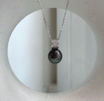 Reflective Tahitian pearl in a hunter green shade with sparkling crystal accents.