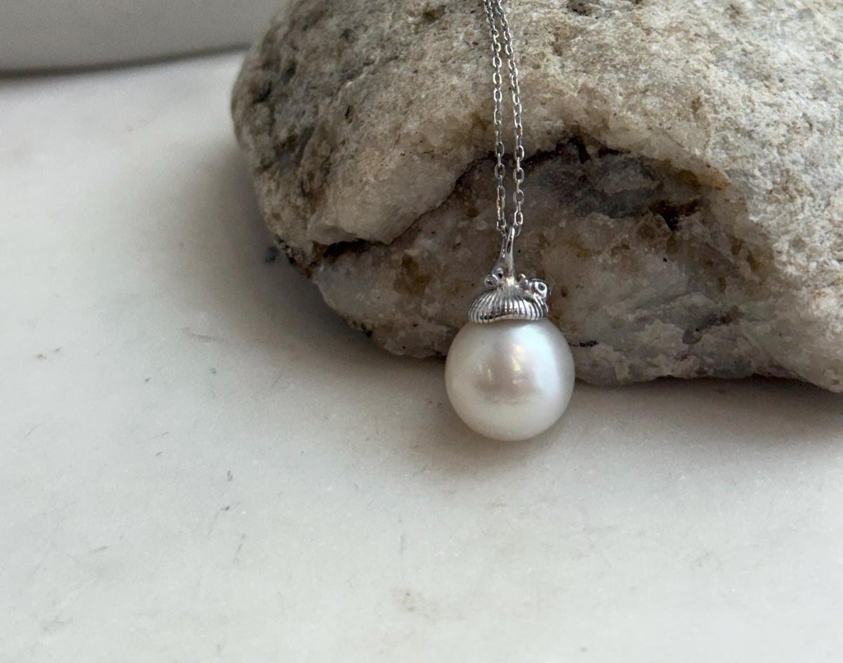 Luminous white South Sea pearl paired with a decorative sterling silver bail and cap.